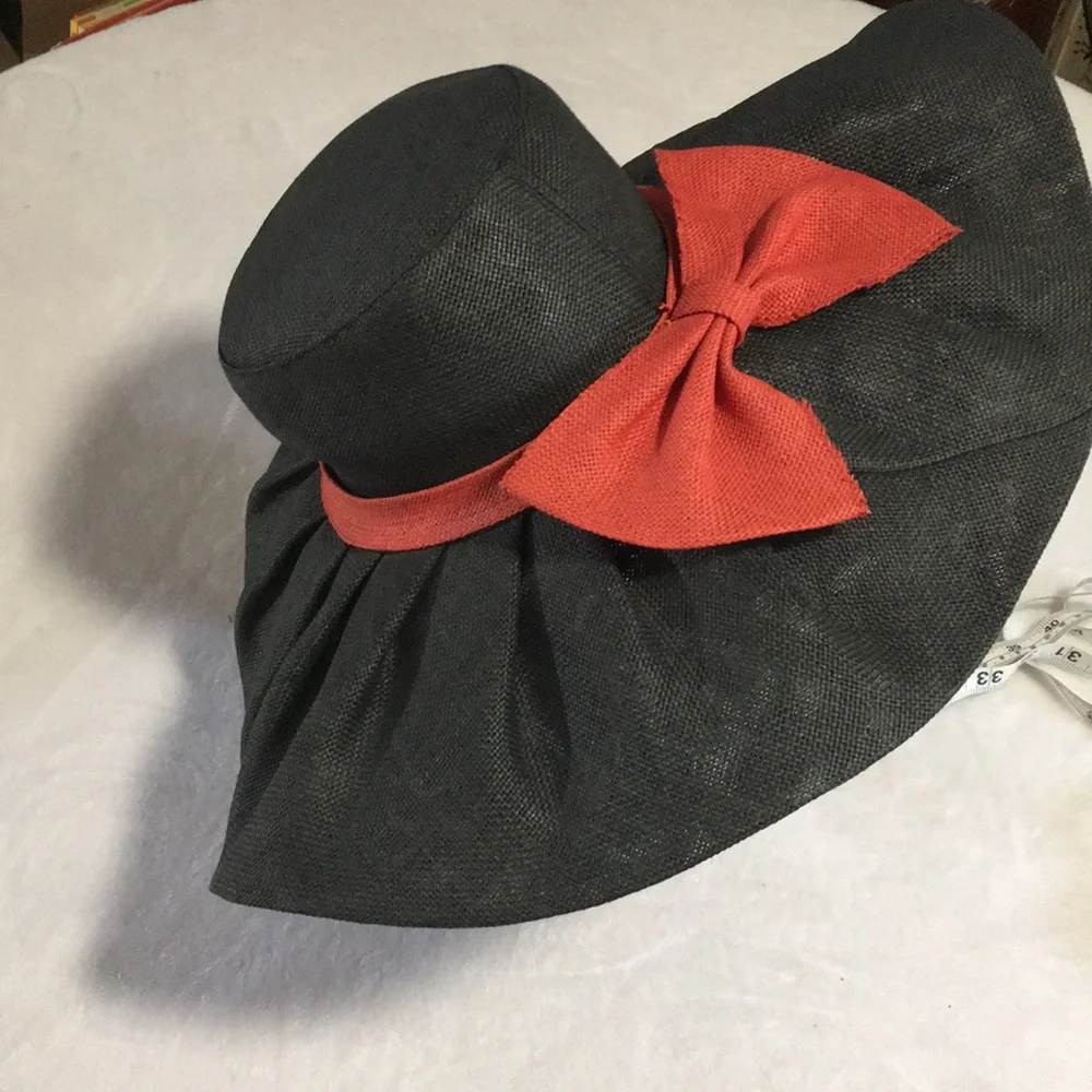 Woman’s black wide brim floppy burlap type hat with red bow.